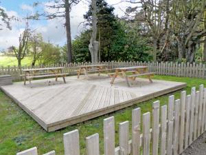 twee banken op een houten platform in een park bij No 3 Low Hall Cottages in Scalby