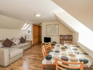 uma sala de estar com uma mesa e um sofá em 10 Monarch Country Apartments em Newtonmore