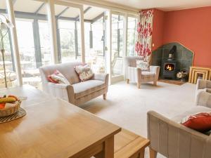 a living room with a table and chairs and a fireplace at Cilfach in Llanfyllin
