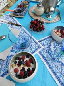 een blauwe tafel met een kom ontbijtgranen en bessen bij Le Pressoir in Beuvron-en-Auge