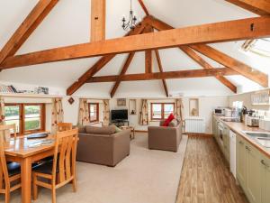 a kitchen and living room with wooden beams at Lundy View Cottage in Great Torrington