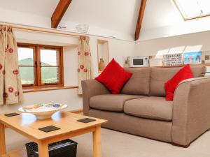 a living room with a couch and a table at Lundy View Cottage in Great Torrington