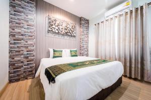 宋卡的住宿－Nice Villa Resort，一间卧室设有一张大床和砖墙