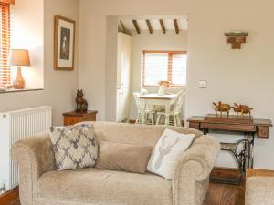 a living room with a couch and a table at Barn Owl Cottage At Crook Hall Farm in Mawdesley