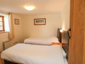 a small room with two beds and a window at Hartland View in Great Torrington