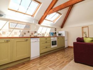 a large kitchen with yellow cabinets and windows at Hartland View in Great Torrington