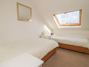 une chambre avec deux lits et une fenêtre dans l'établissement Old Orchard Cottage, à Barmby on the Moor