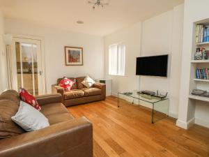 a living room with a couch and a tv at Old Orchard Cottage in Barmby on the Moor