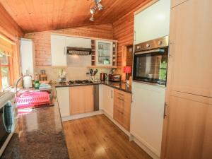 a kitchen with white appliances and wooden walls at Striding Edge in Windermere