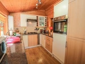 ウィンダミアにあるStriding Edgeの白い家電製品と木製の壁が備わるキッチン