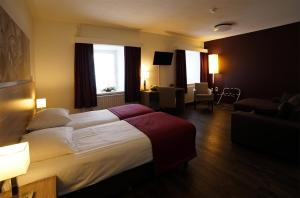 a hotel room with a large bed and a living room at Abdij Hotel Rolduc in Kerkrade