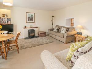 Una sala de estar con un sofá y una chimenea. en Garth Craig, en Porthmadog