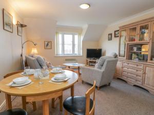a living room with a table and chairs and a tv at Whitby Harbour Retreat in Whitby