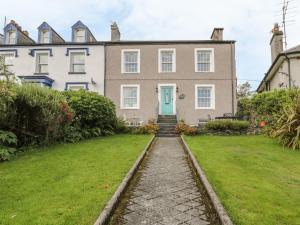una casa con una puerta verde y un patio en Garth Craig en Porthmadog