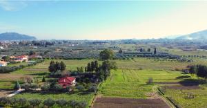 una vista aerea di un'azienda agricola con campi e alberi di Loukas Farm House ad Áyios Kírikos