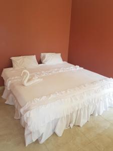 a white bed with a swan laying on it at Glenmore Guest house in Durban