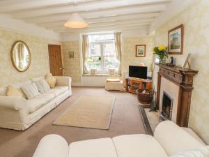 a living room with white furniture and a fireplace at The Homestead in Hawes