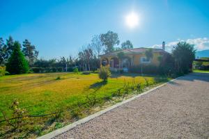 a house with a fence in front of a yard at Loukas Farm House in Ayios Kirikos