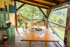 a wooden table on the porch of a house at Nebo nad Štiavnicou - čarovná chalupa so záhradou in Banská Štiavnica