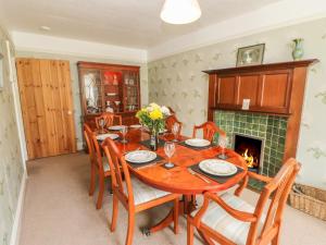 a dining room with a table and chairs and a fireplace at The Homestead in Hawes