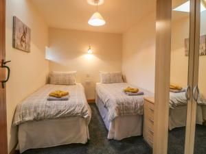 een slaapkamer met 2 bedden en een spiegel bij Dover Barn in Parwich