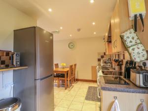a kitchen with a stainless steel refrigerator and a table at Dover Barn in Parwich