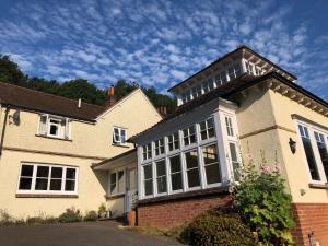 een huis met een groot raam aan de zijkant bij Woodhill Cottage in Holmbury Saint Mary
