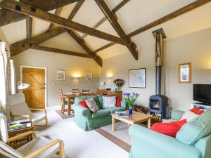 a living room with two couches and a table at The Byre at High Watch in Lanehead