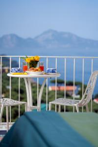 uma mesa com um prato de comida e duas cadeiras em Hotel & Spa Bellavista Francischiello em Massa Lubrense