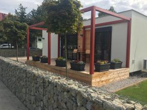 a house with potted plants on a stone wall at Motel M in Malacky