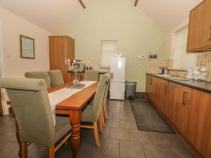 a kitchen with a table and chairs and a refrigerator at Little Argham Cottage in North Burton