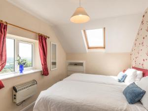 1 Schlafzimmer mit 2 Betten und 2 Fenstern in der Unterkunft Southview in Coreley