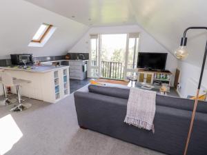 a living room with a couch and a kitchen at The Stilehouse Apartment in Pensax
