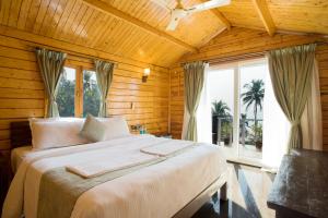 a bedroom with a large bed and a window at Antares Beach Resort, Vagator in Vagator