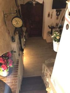 eine Treppe mit einer Uhr an der Wand und Blumen in der Unterkunft B&B La Maison Del Borgo Antico in Bari