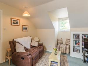 ein Wohnzimmer mit einem Sofa und einem Stuhl in der Unterkunft Southview in Coreley