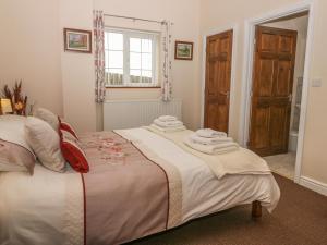 a bedroom with a large bed with towels on it at Little Argham Cottage in North Burton