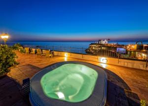 a hot tub on a patio next to the ocean at Hotel Nettuno in Ischia