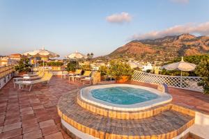 a hot tub on a patio with a view of the mountains at Hotel Nettuno in Ischia