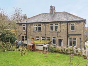 a brick house with a garden in front of it at Fellside in Appletreewick