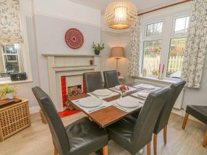 uma sala de jantar com uma mesa e cadeiras e uma lareira em Fellside em Appletreewick
