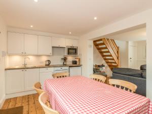 a kitchen and dining room with a table and a couch at 3B Coastguard Cottages in Embleton