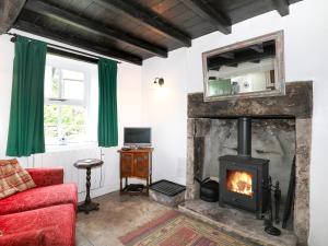 a living room with a fireplace and a red couch at Sunny Bank View in Bradwell