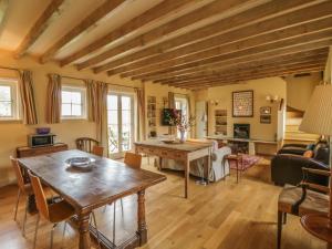 uma sala de estar com uma mesa de madeira e um sofá em Rookwoods em Sible Hedingham