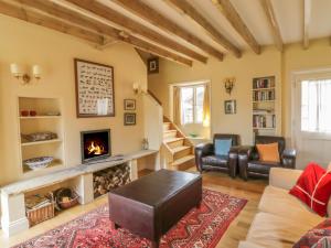 a living room with a fireplace and a couch at Rookwoods in Sible Hedingham