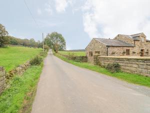 Una calle vacía frente a un edificio de piedra. en Fletchers Barn, en Alderwasley 13 fotos más