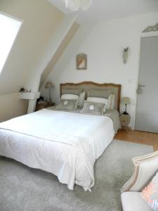 1 dormitorio con 1 cama grande con sábanas y almohadas blancas en Le Pressoir en Beuvron-en-Auge