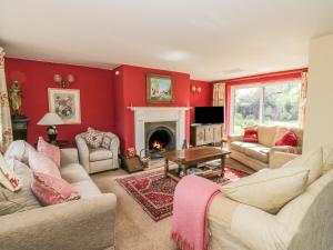 a living room with red walls and a fireplace at Highcroft in Stratford-upon-Avon