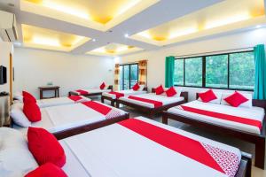 a room with four beds and red pillows at OYO 435 La Veranda Beach Resort in Panglao Island