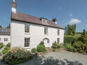 una casa bianca con cancello e vialetto di The Old Schoolhouse and Cottage a Bishops Castle